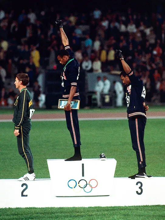 John Carlos and Tommie Smith raise fists in protest as they receive their Olympic medals (1968)